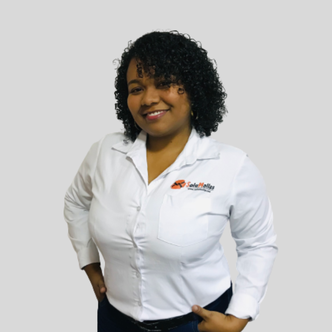 Colaboradora de SoluMallas con camisa blanca y manos en cintura sonriendo